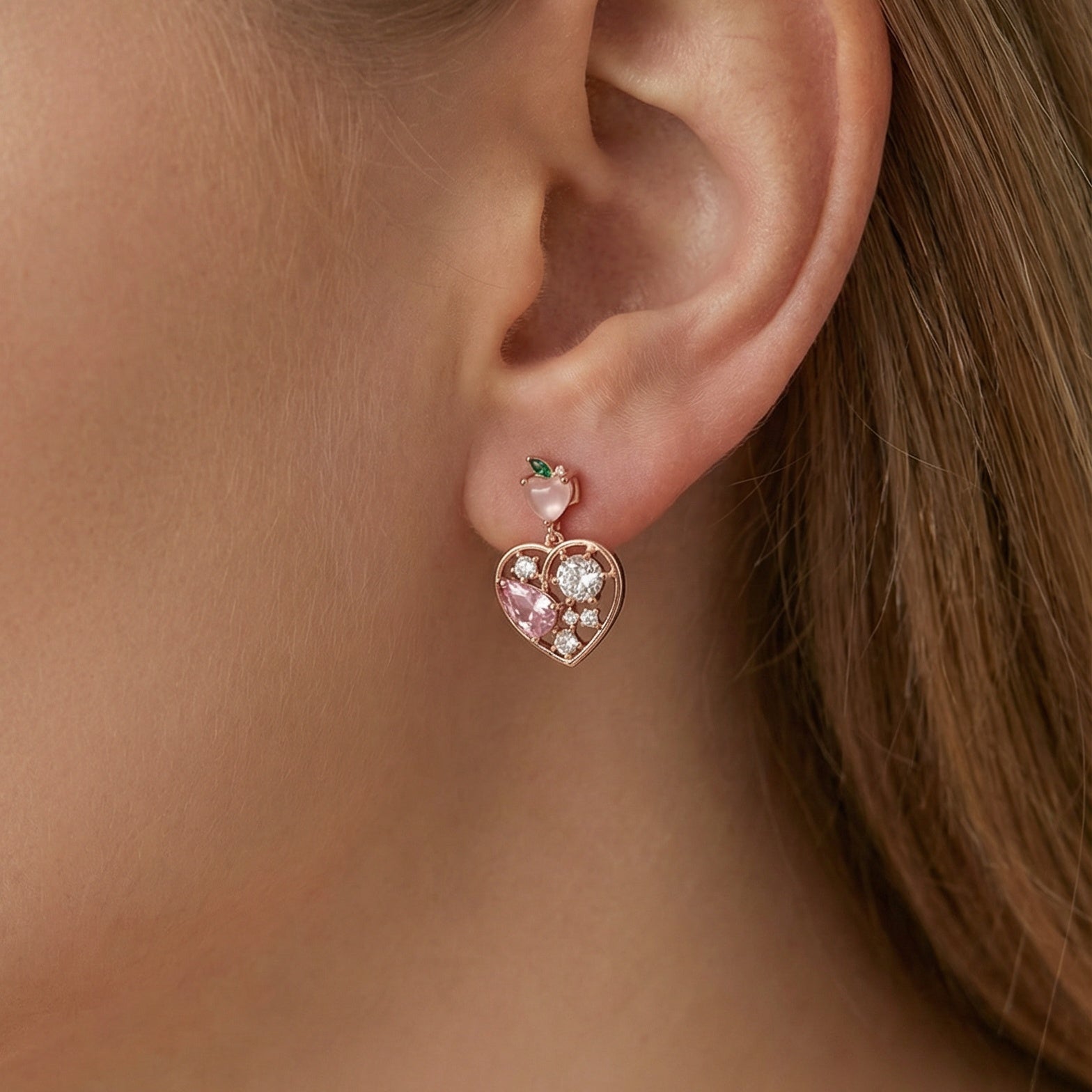 Heart-shaped earrings with gemstones worn by a person